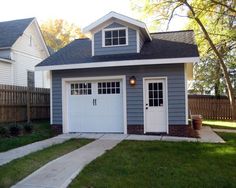 a gray garage with white doors and windows