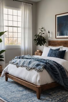 a bedroom with a large bed and blue rug on the floor next to a window