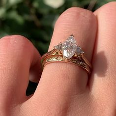 a close up of a person's hand with a gold ring and diamond set