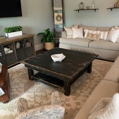 a living room filled with furniture and a flat screen tv mounted to the side of a wall