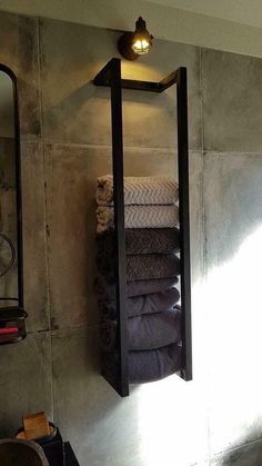 a bathroom with towels hanging on the wall and a mirror in the corner next to it