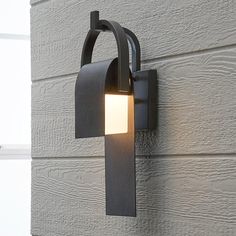 an outdoor wall light on the side of a building with a white light in it