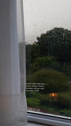 a window with rain drops on it and a poem written in the window sill