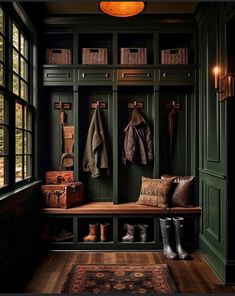 a room with green walls and wooden flooring, two coats hanging on the wall