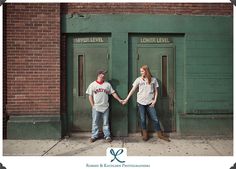 two people holding hands standing in front of green doors with the words lower level on them