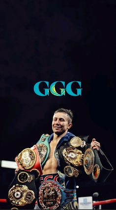 a man standing in the middle of a boxing ring holding two belts