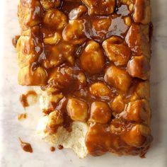 a square piece of bread covered in caramel sauce on top of a white counter