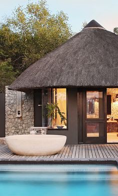 an outdoor bathroom with a large white bowl on the floor next to a swimming pool