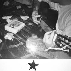 a black and white photo of a person playing an electric guitar with a star on it