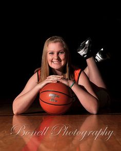 a woman laying on the floor with a basketball