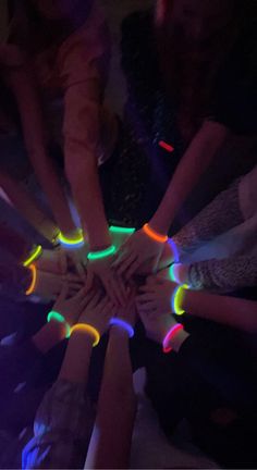 a group of people standing in a circle with their hands on top of each other