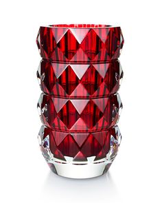 a red glass vase sitting on top of a white table