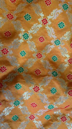 an orange and green fabric with flowers on it