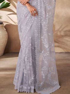 This exquisite ensemble is perfect for celebrating special occasions like parties, receptions, and more. The grey color net saree features intricate threadwork, sequin work, and zarkan work, adding a touch of elegance to your look. Paired with a matching net blouse embellished with the same detailing, this saree set is sure to make you stand out from the crowd.
This saree set includes a 5.50-meter saree length for a graceful drape, along with unstitched blouse material for a customizable fit. Th Elegant Saree With Intricate Embroidery For Celebration, Net Pre-draped Saree For Party And Festivals, Diwali Party Wear Net Saree, Party Wear Net Saree For Reception, Net Saree For Eid Reception, Festive Pre-draped Saree With Self Design, Pre-draped Net Saree With Self Design, Festive Net Saree With Self Design, Party Wear Lehenga With Chikankari Embroidery