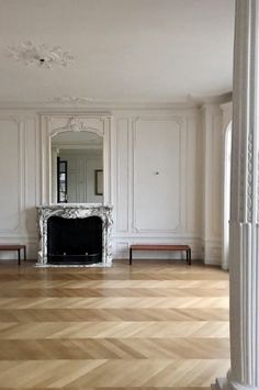 an empty room with white walls and wood floors