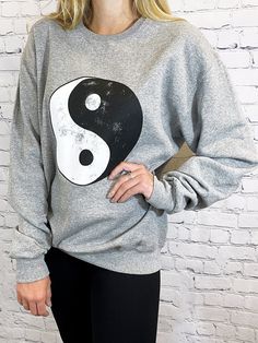 About -Oversized -50% Cotton 50% Polyester -Hand Wash -Crewneck Pullover -Distressed Ying Yang Graphic It's time to pull out your 90's nostalgia out of the back of the closet. We are in love with this oversized crew neck sweatshirt with a distressed ying-yang graphic at the front. We love this paired with a pair of bike shorts or leggings for a casual style for any day of the week. Distressed Crew Neck Sweater For Streetwear, Casual Distressed Sweater For Streetwear, Distressed Grunge Crew Neck Sweatshirt, Distressed Crew Neck Sweatshirt In Grunge Style, Distressed Crew Neck Sweatshirt For Streetwear, Oversized Distressed Crew Neck Sweatshirt, Distressed Oversized Crew Neck Sweatshirt, Casual Distressed Crew Neck Sweater, Casual Soft-washed Sweater For Streetwear