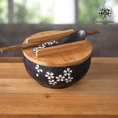 a black and white bowl with spoons in it