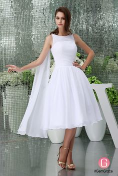 a woman in a white dress posing for the camera