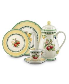 a tea set with an apple design on the front, and two cups and saucers