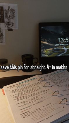 an open book sitting on top of a desk next to a computer monitor