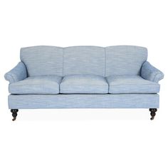 a light blue couch sitting on top of a white floor next to a wooden frame