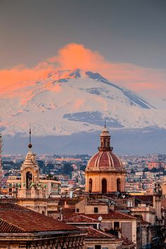 a view of a city with snow covered mountains in the back ground and buildings below