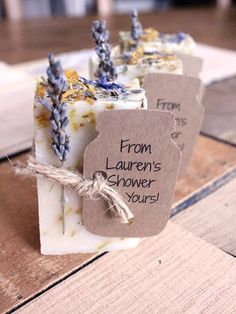 three soap bars with tags on them sitting on a wooden table next to each other