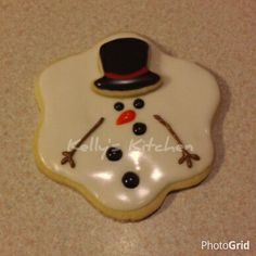 a cookie decorated like a snowman wearing a top hat