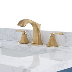 two golden faucets on a marble counter top