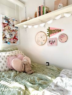 there is a stuffed animal sitting on the bed in this small room with many bookshelves