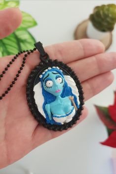 If you are a fan of Tim Burton like me, this Emily the Corpse Bride pendant is just for you! It would be a great choice to wear on Halloween. Or you can gift it to your goth friend :) This necklace is hand sculpted with polymer clay on a black cameo pendant. #corpsebridenecklace #emilythecorpsebride #timburtonstyle #halloweenaccessories #gothicjewelry Handmade Whimsical Jewelry For Cosplay, Whimsical Handmade Jewelry For Cosplay, Handmade Blue Jewelry For Cosplay, Blue Handmade Jewelry For Cosplay, Themed Polymer Clay Jewelry For Gifts, Handmade Halloween Pendant Necklace, Handmade Pendant Necklace For Halloween, Handmade Pendant Necklace For Cosplay, Unique Handmade Necklaces For Cosplay