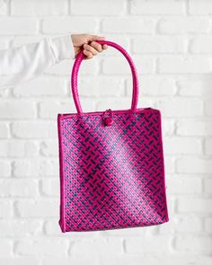 Fusia Pink Woven Bag With Handles, Straw Tote Bag, Shopping Tote BagOur totes are as functional as they are beautiful. Naturally dyed and lovingly handwoven, we know they will be a vibrant addition to your closet or as a gift. These totes are made by weavers in Chiangmai, Thailand where they use the Pandanus leaf as their material. 12"H x 11"W20"H x (with handle)The tote can hold up to 4lbs. Just enough to hold your MacBook.SOCIAL IMPACT | FAIR TRADE | HANDMADEYour purchase supports the basketry Pink Tote Shoulder Bag With Braided Handles, Pink Satchel Shoulder Bag For Beach, Pink Shoulder Bucket Bag With Braided Handles, Pink Satchel Shoulder Bag For The Beach, Pink Handheld Gift Bag, Purple Bags With Braided Handles For Daily Use, Pink Square Crochet Bag For Beach, Purple Square Bags For Summer, Purple Rectangular Shoulder Bag With Braided Handles