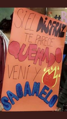 a man holding up a sign in spanish