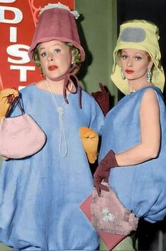 two mannequins dressed in blue dresses and hats, one holding a purse