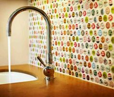 a faucet that is next to a sink in a room with colorful wallpaper