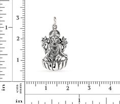 This 3.5mm high pendant is cast from .925 sterling silver oxidized to show detail. It represents Lakshmi, the goddess of wealth, fortune and prosperity in both Hindu and Buddhist religions. She is often depicted sitting like a yogi on a lotus pedestal, holding a lotus in her hand - the lotus being a symbol of good fortune, self-knowledge, and spiritual liberation. Her four arms represent the four directions, thus symbolizing the omnipresence and omnipotence of the Goddess, while her four hands r Sterling Silver Temple Jewelry For Meditation, Silver Symbolic Jewelry For Diwali, Spiritual Antique Silver Jewelry With Charms, Antique Silver Spiritual Jewelry With Charms, Spiritual Antique Silver Charms Jewelry, Antique Silver Spiritual Charms Jewelry, Spiritual Engraved Jewelry For Diwali, Sterling Silver Jewelry For Diwali Puja, Symbolic Sterling Silver Jewelry For Puja