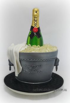 a cake shaped like a bucket with ice in it and a bottle of champagne on top