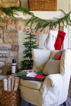 a living room decorated for christmas with stockings on the fireplace mantel and tree branches