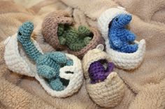 several crocheted baby shoes are laying on a blanket with stuffed animals in them