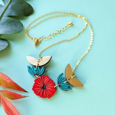 "This abstract Scandinavian poppy necklace is a vibrant and modern piece that makes a perfect gift or art statement for yourself! This original necklace is hand painted on cherry wood in a palette of red, teal, and gold and features abstract flowers and leaves strung together for a fun and modern work of art. If you love scandi, mid-century modern, or abstract art, this necklace is for you! This necklace comes with a 17in 24k gold-plated brass cable chain with a lobster clasp and gold-plated ext