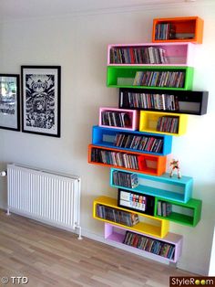 there is a multicolored book shelf next to the radiator in this room