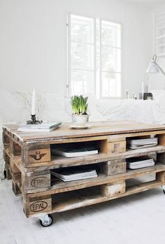 a living room with white walls and wooden pallets on the floor, including a coffee table