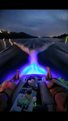 two people on a boat in the water at night