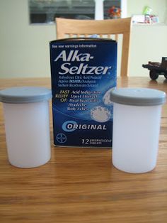 two plastic containers sitting on top of a wooden table next to a carton of milk