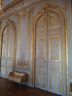 an ornately decorated room with white walls and gold trimmings on the doors