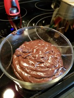 a pan filled with chocolate sitting on top of an oven