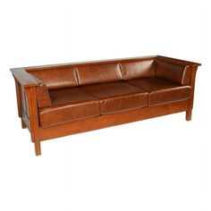 a brown leather couch sitting on top of a wooden frame