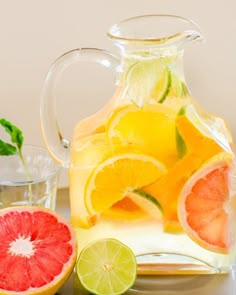 a pitcher of lemonade and sliced grapefruit on a table