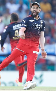 a man in red pants is playing cricket