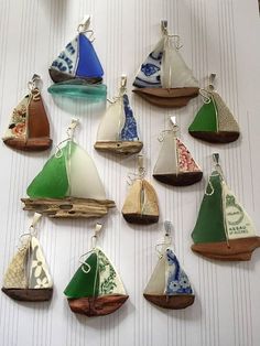 there are many small sailboats hanging on the wall